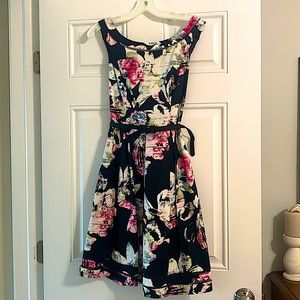 Black/multi colored Fit and Flair dress. Zips up the back. Lined. With belt.